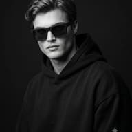 Low-Key Fashion Portrait AI Photo Editing Prompt. AI generated studio portrait of a young man in a black hoodie wearing dark sunglasses.