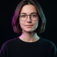 Neon Lighting Woman Portrait AI Photo Editing Prompt. AI generated portrait of a young woman with a short bob and glasses, illuminated by contrasting magenta and cyan neon lights against a black background.