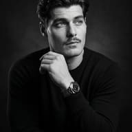 AI Photo Prompt: Dramatic black-and-white portrait of a man with a mustache and hand near chin.
