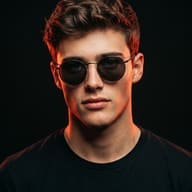 AI generated studio portrait of a young man wearing round dark sunglasses and a black t-shirt, illuminated by dramatic red edge lighting.