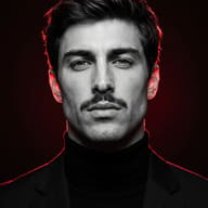 Dramatic Red Neon Rim Light Portrait AI Photo Editing Prompt. AI generated black and white portrait of a mustached man with wavy hair in a black turtleneck and blazer, lit by glowing red rim lighting against a dark background.