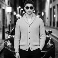 Black and white urban street photography AI Photo Editing Prompt. AI generated cinematic portrait of a handsome stylish man wearing a knit cardigan and sunglasses standing in front of a car at night.