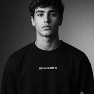 Moody Monochrome Portrait AI Photo Editing Prompt. AI generated photography portrait capturing the intense, contemplative gaze of a young man wearing a black 'ONLY GOD CAN JUDGE ME' sweatshirt.