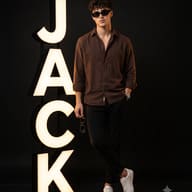Glowing 3D Letters Studio Photography AI Photo Editing Prompt. AI generated studio portrait of a stylish young man with sunglasses standing beside large glowing letters spelling JACK.