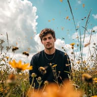 Gemini AI generated an aesthetic nature photo of a young guy surrounded by blooming yellow flowers and blurred bees under a vibrant turquoise cloudy sky.