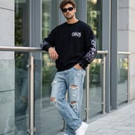 Urban Streetwear Fashion Portrait AI Photo Editing Prompt. AI generated outdoor portrait of a stylish young man wearing a black "CHAOS" sweatshirt, ripped jeans, and sunglasses leaning against a glass railing in a modern city setting.