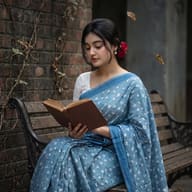 AI generated Retro Vintage inspired portrait of a serene woman in a blue floral saree reading on a rustic bench, evoking a nostalgic, quiet luxury mood.