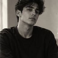 ChatGPT AI Photo Prompt: Moody monochrome editorial portrait of a young man with messy hair looking directly at the camera with an authentic analog film aesthetic.