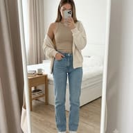AI Mirror Selfie Prompt for Girl. AI generated portrait of a woman in a beige top and jeans taking a bedroom selfie.