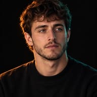 Cinematic Dual-Tone Portrait AI Photo Editing Prompt. AI generated studio portrait of a young man in a black sweater, lit with warm orange and cool teal split lighting against a black background.