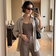 Indian Woman mirror selfie photography AI Photo Editing Prompt. AI generated lifestyle photograph of a stylish young woman wearing a brown corset top, beige shirt, and sunglasses taking a mirror selfie in a modern minimalist room.