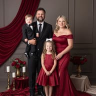 Formal Family Studio Photoshoot AI Prompt. AI generated studio portrait of a formal family with parents, a son, and a daughter in crimson attire, posing in a decorated studio with velvet drapes and floral arrangements.