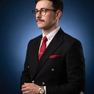 Gemini AI generated Editorial profile portrait of a stylish man with glasses and a mustache wearing a black suit and luxury watch against a glowing blue background.