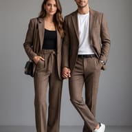 Couple in Matching Plaid Suits AI Photo Editing Prompt. AI generated studio portrait of a stylish couple holding hands while wearing coordinated brown plaid suits in a modern studio setting