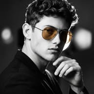 AI Photo Prompt: Black and white editorial image of a young man with curly hair and color-pop amber glasses.