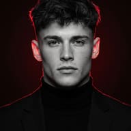 AI generated portrait of a young man with dark wavy hair in a black turtleneck and blazer, with dramatic red rim lighting against a dark background.