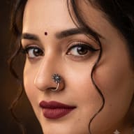 Close-up Indian Woman Portrait with Bindi and Nose Ring AI Photo Editing Prompt. AI generated close-up portrait of a South Asian woman wearing a maroon bindi, a detailed silver flower nose ring, dramatic winged eyeliner, deep maroon lipstick, and a variety of star-shaped ear studs against a warm background.