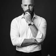 Monochrome Studio Portrait AI Photo Editing Prompt. AI generated studio portrait of a pensive bald, bearded man in a white shirt.