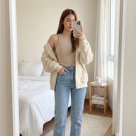 Woman Mirror Selfie Photo Prompt. AI generated, mirror selfie portrait of a young woman wearing a beige ribbed tank top and cardigan with blue jeans in a minimal bedroom.