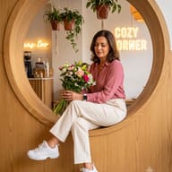 AI generated photo portrait of a seated woman in a pink shirt holding a colorful bouquet, looking down inside a circular wooden frame.