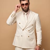 Man in Cream Double-Breasted Suit Portrait. AI Photo Editing Prompt. AI generated studio portrait of a man in a cream double-breasted suit, adjusting aviator sunglasses with a gold watch visible.
