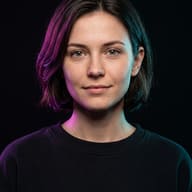 AI generated studio portrait of a young woman with glasses illuminated by purple and cyan lights on a dark background.