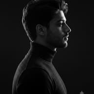 Indian Men Black & White Dramatic Profile Portrait AI Photo Editing Prompt. AI generated high-quality studio portrait of a man in profile wearing a black turtleneck, featuring stark chiaroscuro lighting on his face.