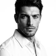 Classic Black and White Studio Portrait AI Photo Editing Prompt. AI generated studio portrait of a handsome man wearing a crisp white button-down shirt and looking directly into the camera.