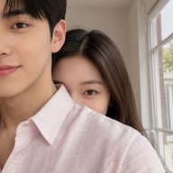 Candid couple photography AI photo editing prompt. AI generated close-up selfie of a boyfriend in a pink shirt with his girlfriend peeking behind his shoulder."