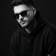 Black and White Man Portrait AI Photo Editing Prompt. AI generated photo-realistic portrait of a young man wearing dark sunglasses and a black hoodie.