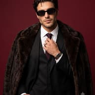 Man in Fur Coat Fashion Portrait AI Photo Editing Prompt. AI generated studio portrait of a sophisticated older gentleman wearing a dark three-piece suit, sunglasses, and a heavy fur coat over his shoulders against a maroon background.   