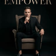 Man in Black Suit in Armchair AI Photo Editing Prompt. AI generated studio portrait of a man in a black suit sitting in a brown wingback armchair under the word EMPOWER on a black background.
