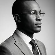 Professional Man in Monochrome Suit AI Photo Editing Prompt. AI generated monochrome studio portrait of a Black man wearing a suit, paisley tie, and rimless glasses.